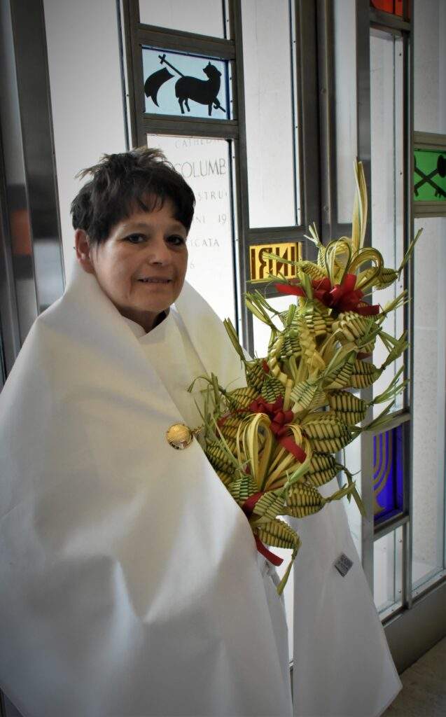 Altar server holds elaborate arrangement of palms