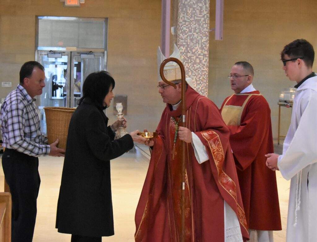 Parishioners bring the gifts forward during Palm Sunday Mass