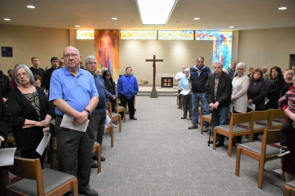 Congregation stands during Good Friday Mass at St. William Parish