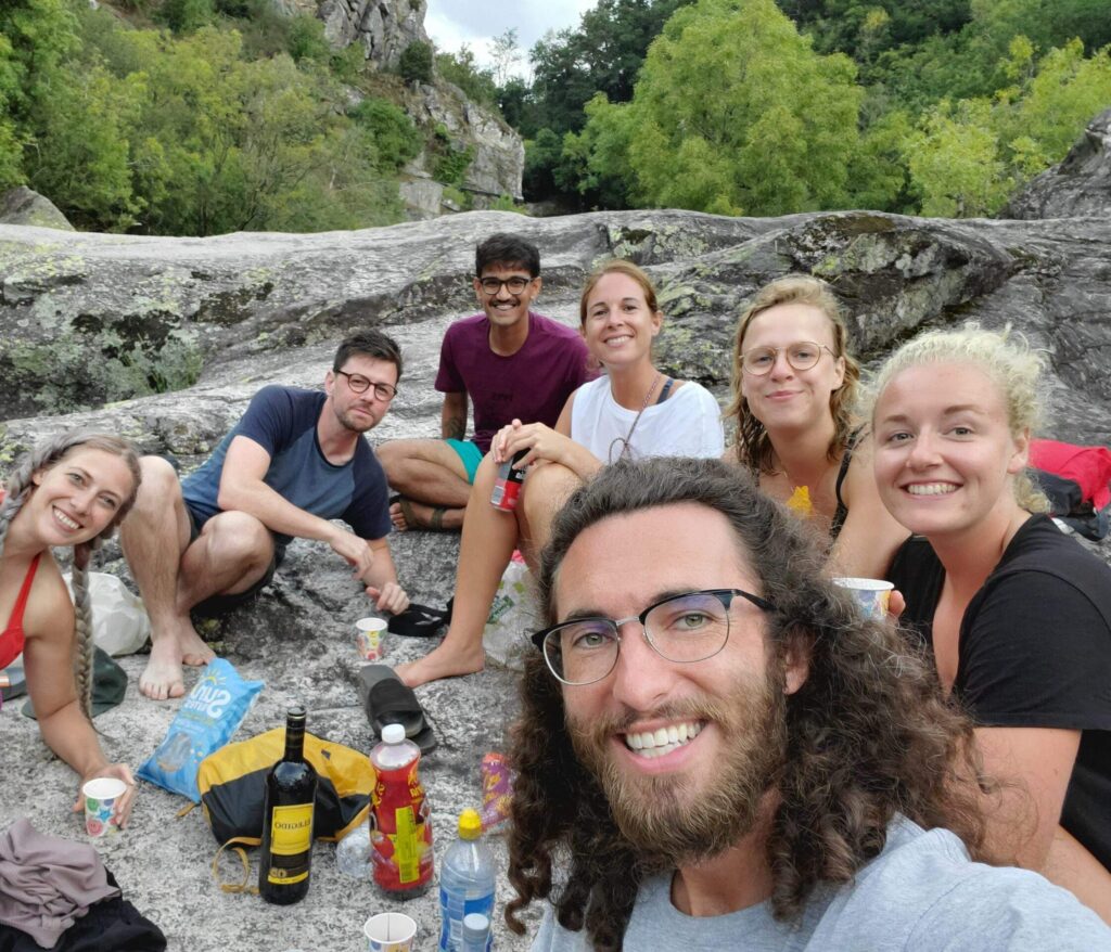 Mitchell poses with a group of six other pilgrims as they stop for lunch on a rocky trail.