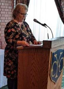 Mary Fiala speaks at a podium.