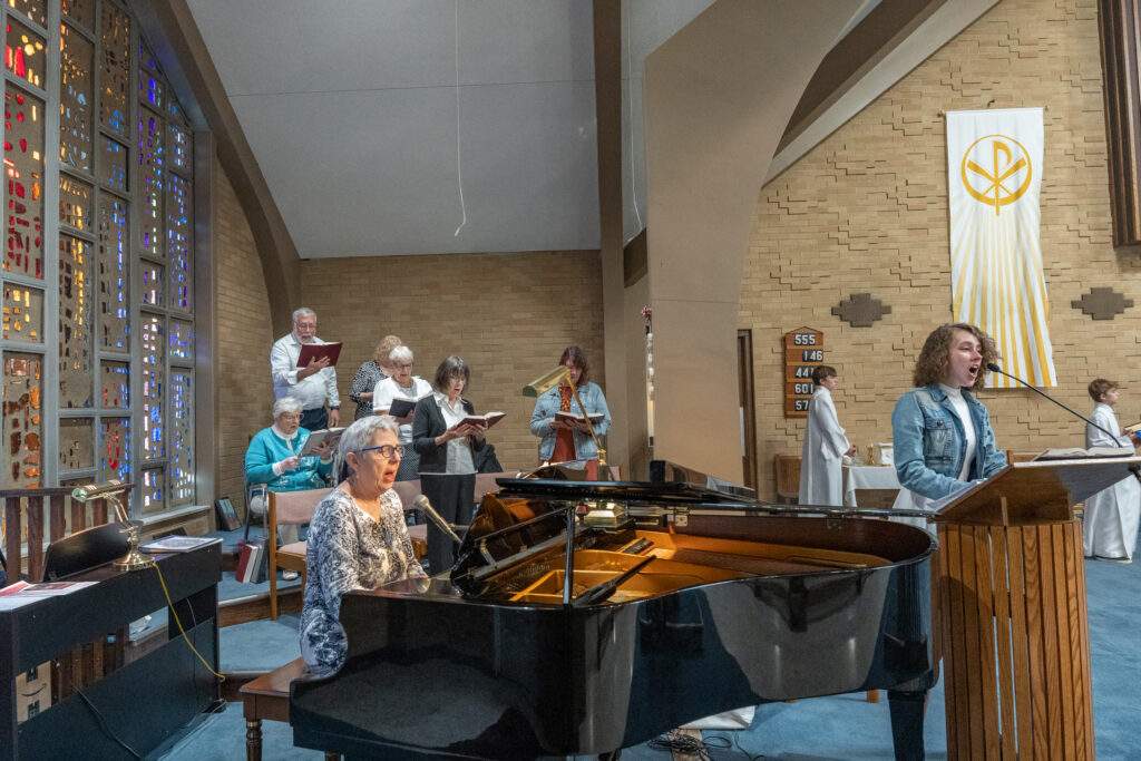Choir and cantor sing, accompanied on the piano during the altar blessing at St. Mary Parish in Orwell. Photo by Brian Keith