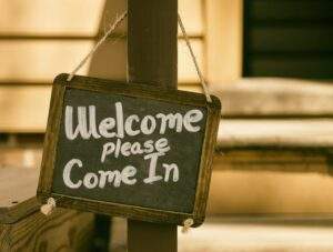 chalkboard sign reading "welcome, please come in"