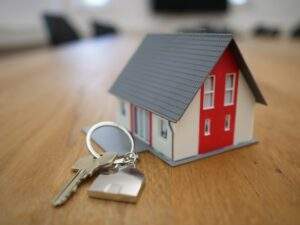 Model house next to a house key on a keychain