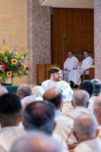 Father Schueter turns and smiles at his family during his ordination.