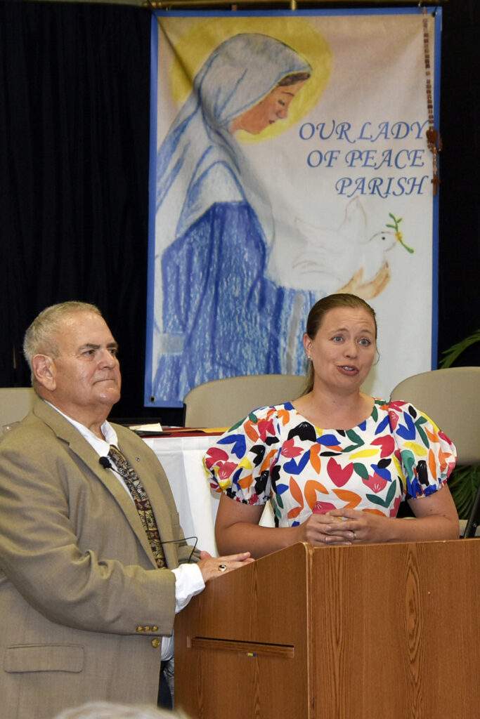 Opening soloist stands at the podium at the Knights of Columbus Ashtabula merger ceremony