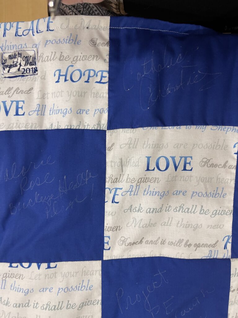 Quilt featuring blue and white squares from the Tri-County Patchworking Event