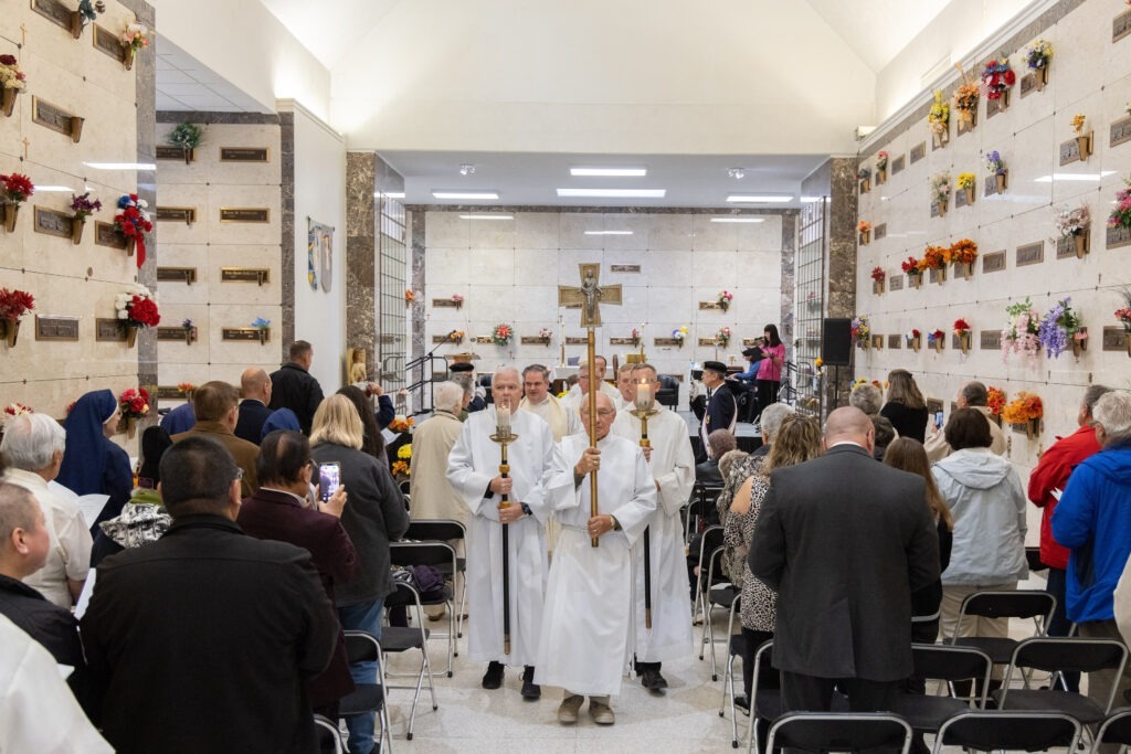Participants stand during the recessional hymn at St. Callistus Feast Day on October 14, 2024, at Calvary Cemetery in Massillon.