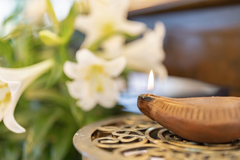 photo of incense, with lillies in the background. Photo by Brian Keith.