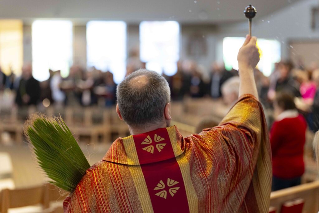 Father Celuch sprinkles holy water on his parishioners. Photo by Brian Keith