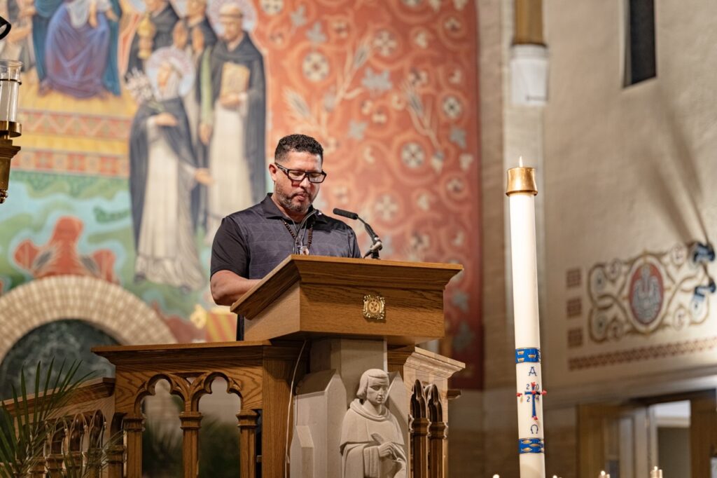 Lector stands at the ambo at the Easter Vigil 2024 at St. Dominic's. Photo by Brian Keith.