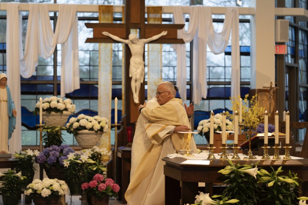 Priest and deacon hug on Easter Sunday at Blessed Sacrament Parish in Warren. Photo by Brian Keith.