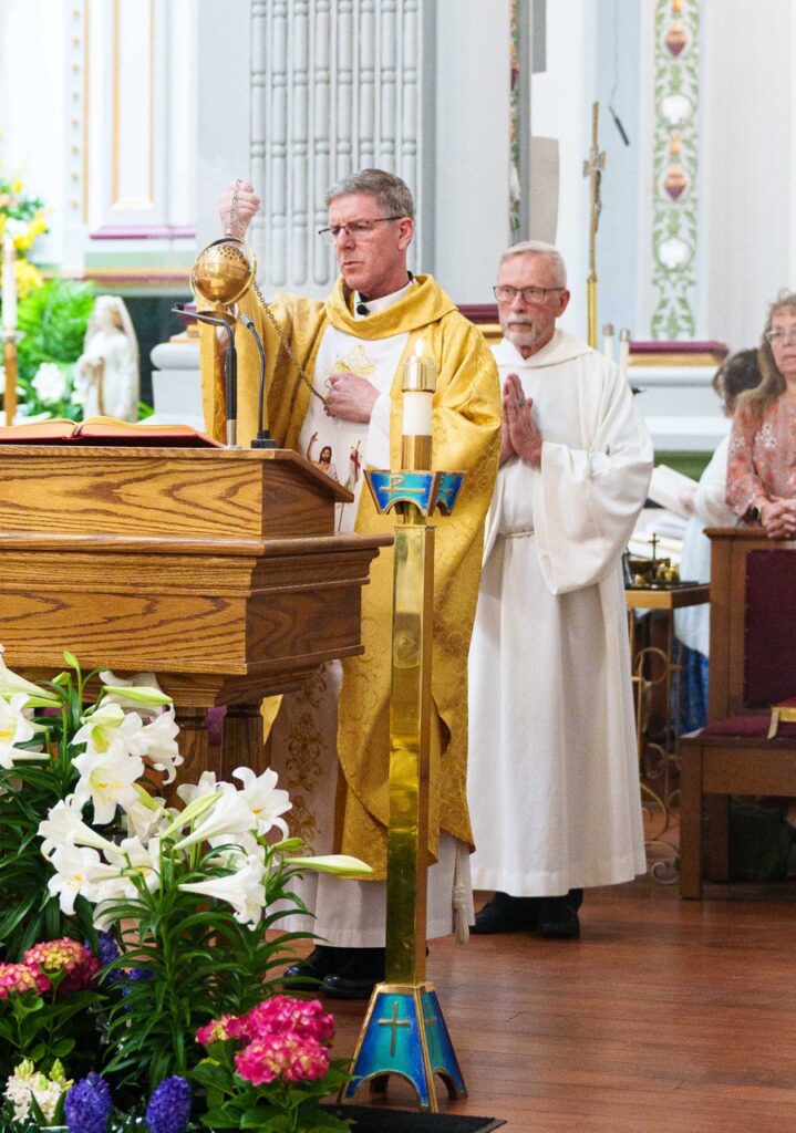 Priest incenses the Bible at the Easter Vigil 2024 at Holy Trinity Parish in East Liverepool. Photo by Jimmy Joe Savage.