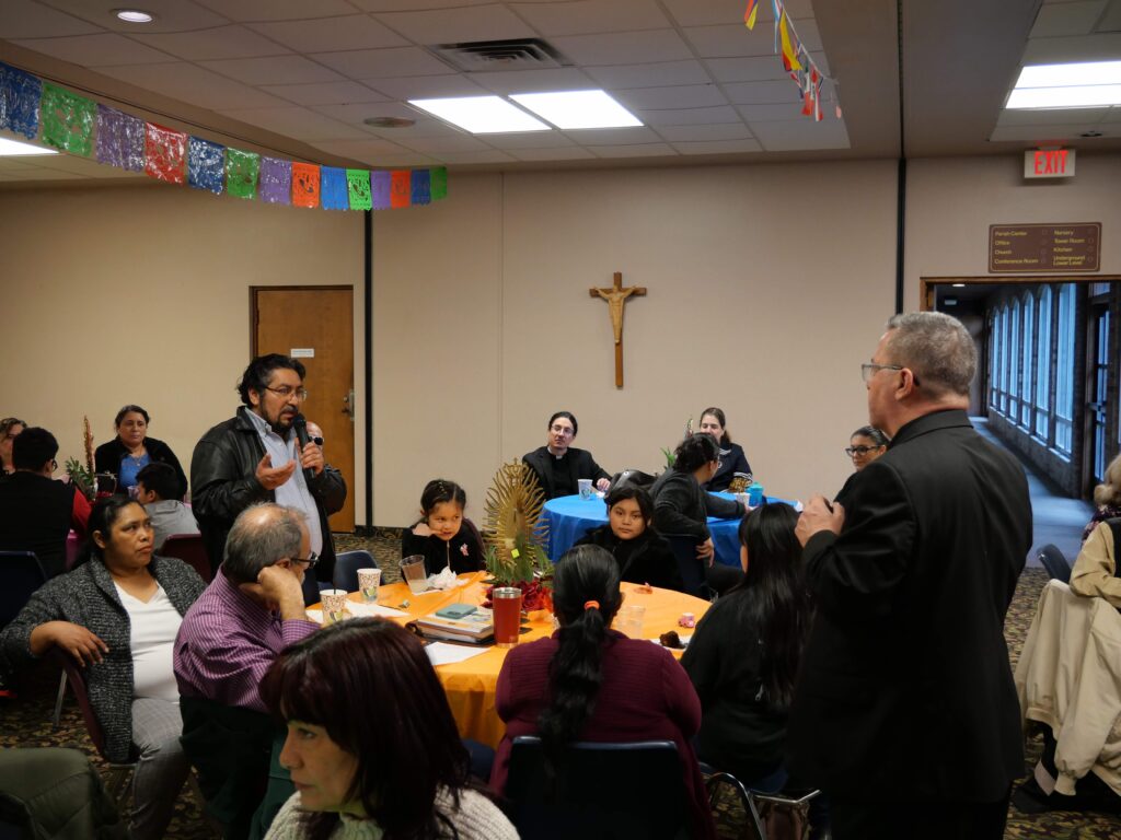 Bishop bonnar answers a question from a man, standing at a table