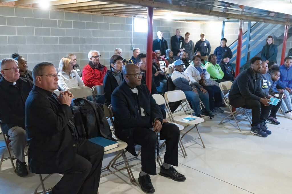 Bishop Bonnar sits with the rest of the crowd who attended the Mathis Family house blessing.