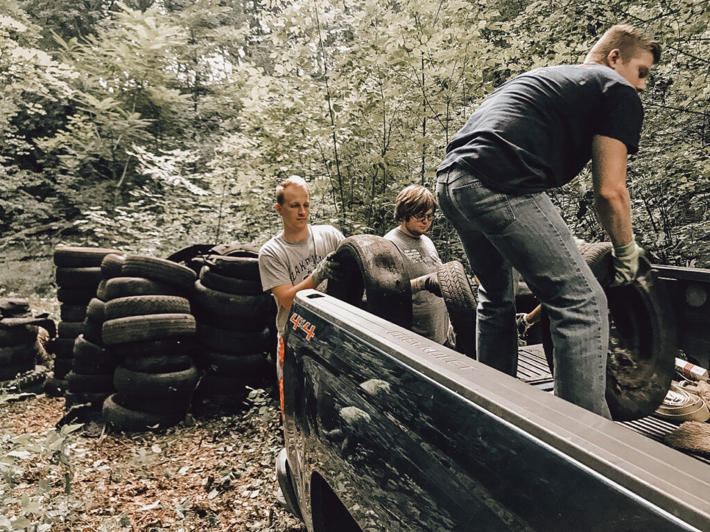 A man lifts a tire into a truck.