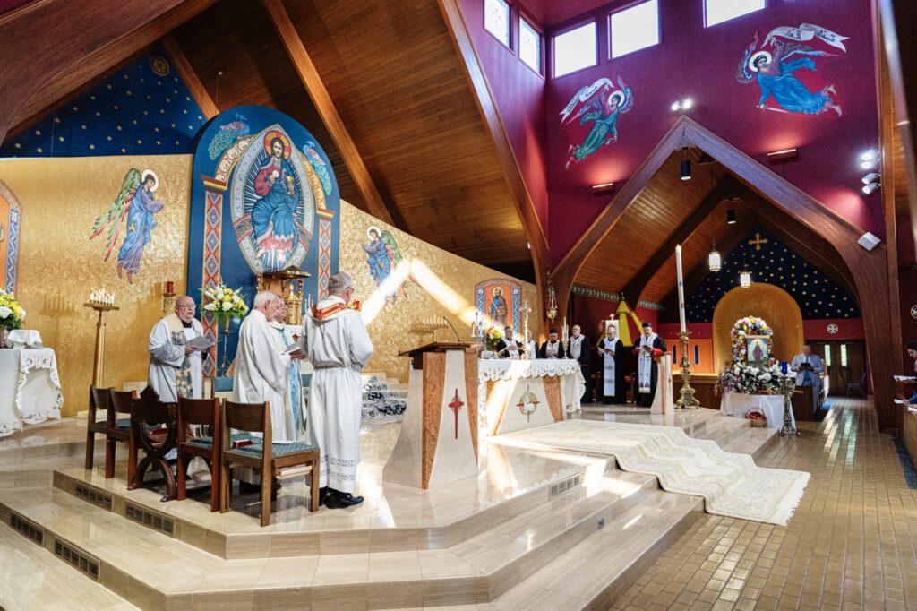 A large group of priests and deacons celebrate Mass for the Assumption Pilgrimage in North Jackson. Photo by Brian Keith.
