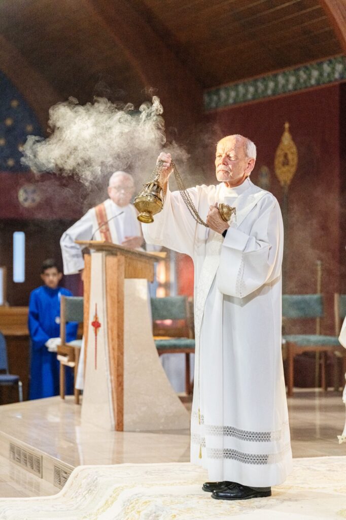 A man in white vestment incenses the altar for the Assumption Pilgrimage in North Jackson. Photo by Brian Keith.